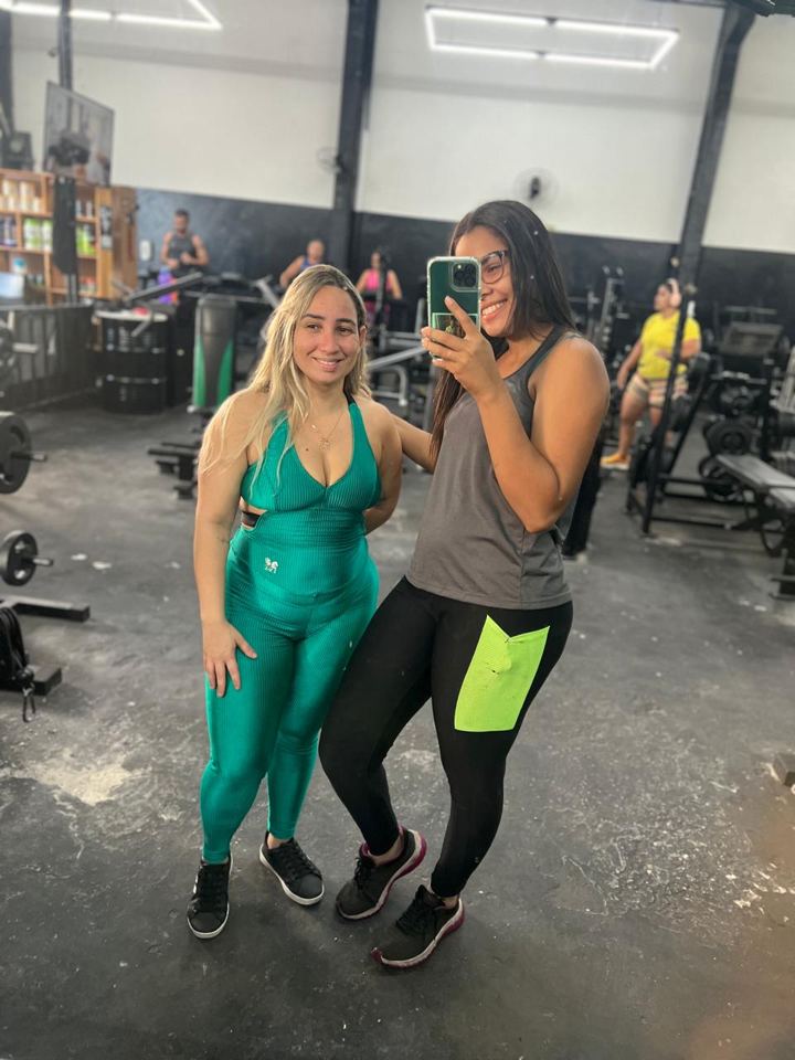 Lis e uma aluna em selfie no espelho da área de musculação